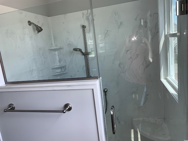 bathroom with tiled shower and plenty of natural light