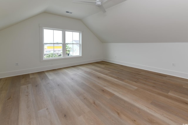 additional living space with light hardwood / wood-style flooring, ceiling fan, and vaulted ceiling