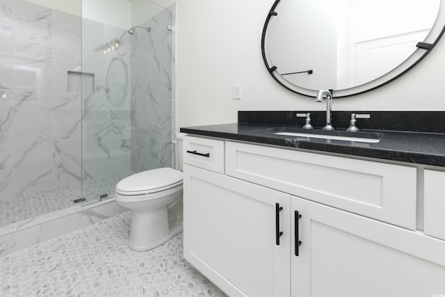 bathroom featuring vanity, a shower with door, and toilet