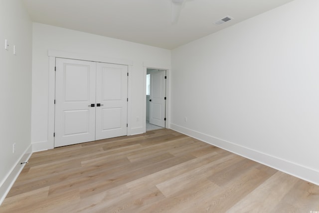 unfurnished bedroom featuring a closet and light wood-type flooring