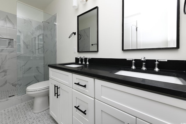 bathroom with vanity, toilet, and tiled shower