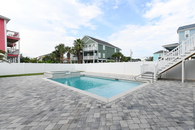 view of swimming pool featuring a patio and an in ground hot tub