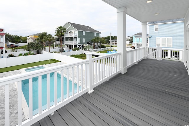 wooden terrace featuring a swimming pool with hot tub