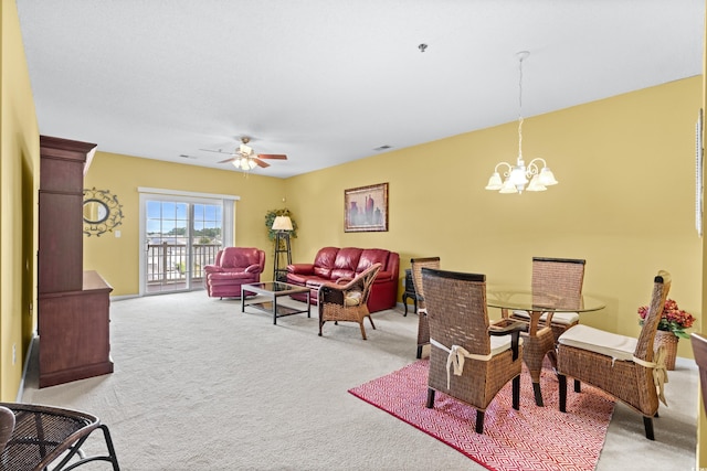 sitting room featuring ceiling fan with notable chandelier and light carpet