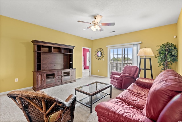 living room with a textured ceiling, ceiling fan, and carpet