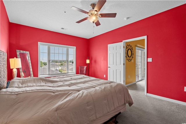 carpeted bedroom with ceiling fan and a textured ceiling