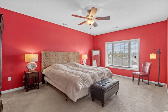 bedroom featuring a textured ceiling, carpet, and ceiling fan
