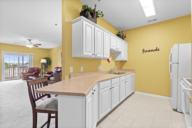 kitchen featuring light colored carpet, ceiling fan, white appliances, and white cabinetry
