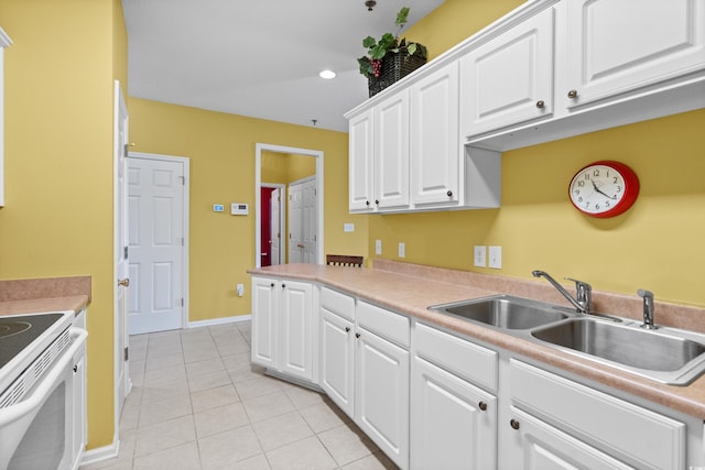 kitchen with sink, light tile patterned floors, white electric range oven, and white cabinets