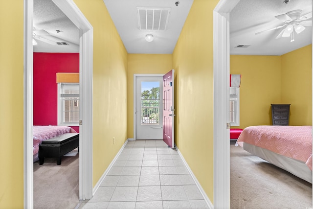 bedroom featuring light colored carpet, ceiling fan, and a textured ceiling