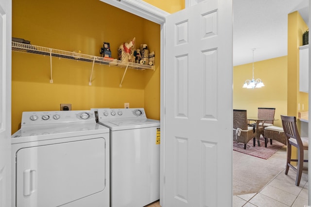 laundry room with a chandelier, washing machine and clothes dryer, and light tile patterned floors