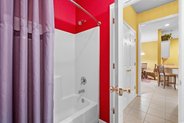 bathroom featuring a textured ceiling, tile patterned floors, and shower / bath combo with shower curtain