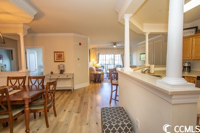 interior space featuring decorative columns, light wood-type flooring, ceiling fan, and sink