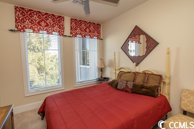 carpeted bedroom with multiple windows and ceiling fan