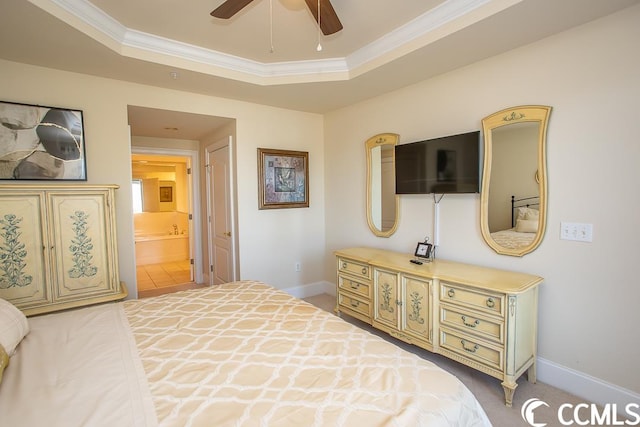 tiled bedroom featuring ceiling fan, ornamental molding, ensuite bathroom, and a tray ceiling