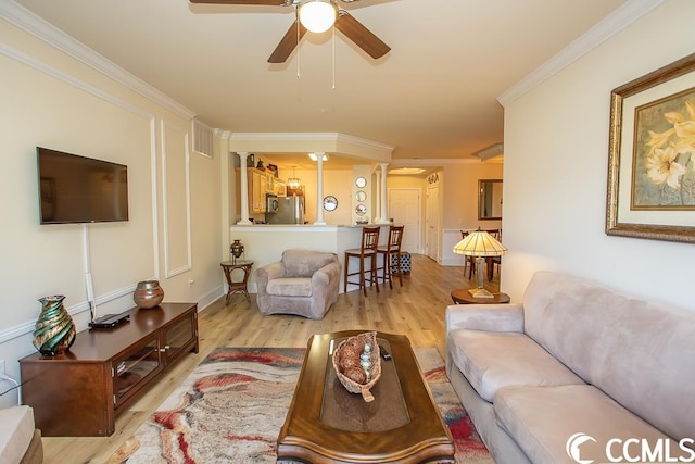 living room with light hardwood / wood-style flooring, ceiling fan, and crown molding