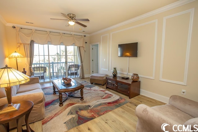 living room featuring ceiling fan, crown molding, and light hardwood / wood-style flooring