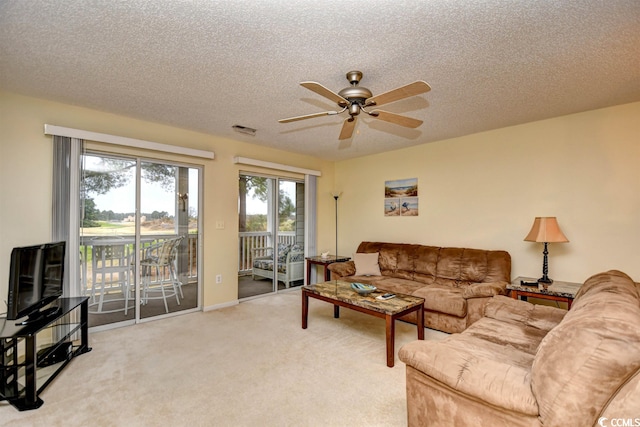 carpeted living room with a textured ceiling and ceiling fan