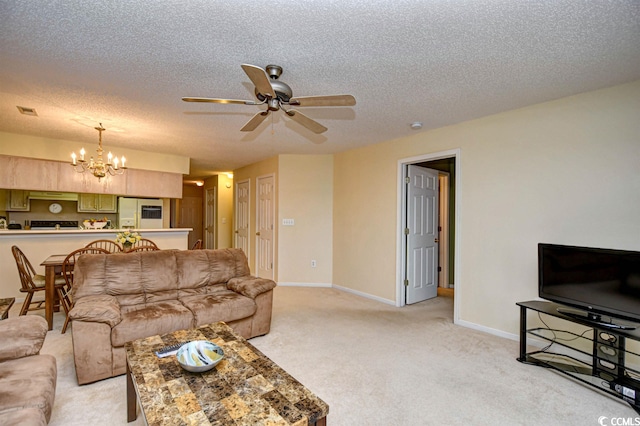 carpeted living room featuring a textured ceiling and ceiling fan with notable chandelier