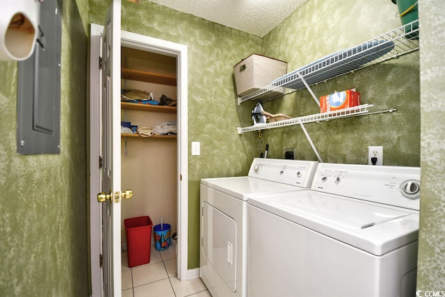 laundry room with washer and clothes dryer, a textured ceiling, and light tile floors