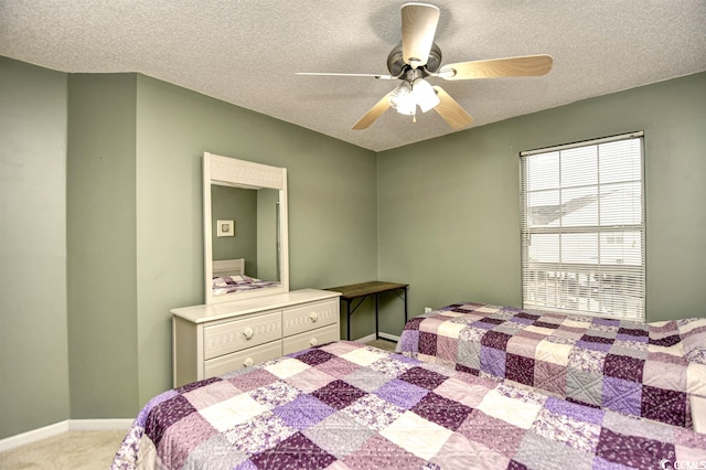 carpeted bedroom featuring ceiling fan and a textured ceiling