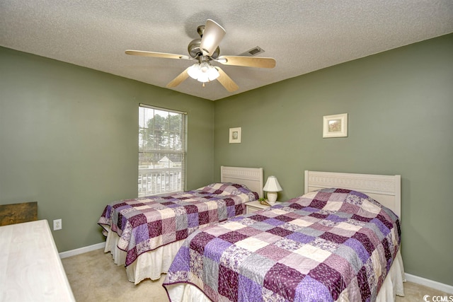 carpeted bedroom featuring a textured ceiling and ceiling fan