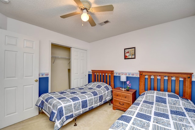 carpeted bedroom with a textured ceiling, a closet, and ceiling fan