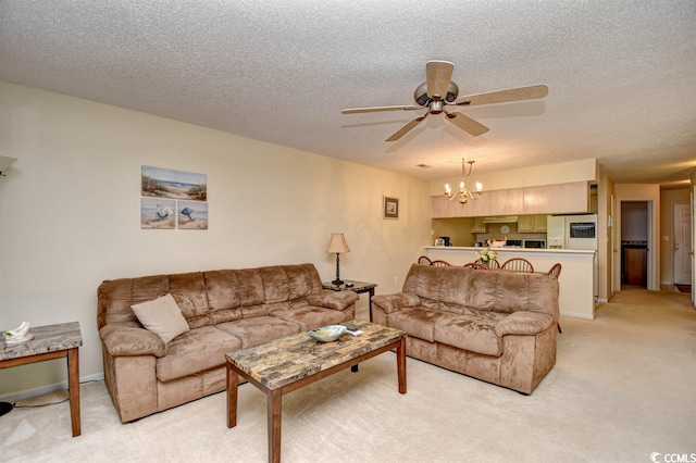 living room featuring light carpet, ceiling fan with notable chandelier, and a textured ceiling