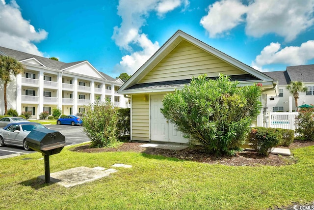 view of front facade featuring a front yard and a balcony