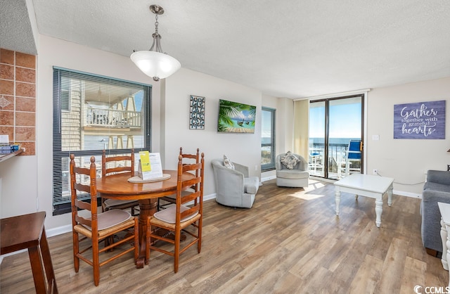 dining space featuring a textured ceiling and hardwood / wood-style floors