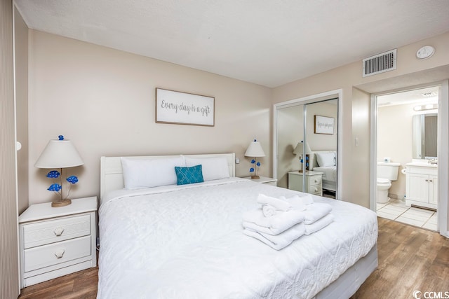 bedroom featuring a closet, hardwood / wood-style flooring, and a textured ceiling