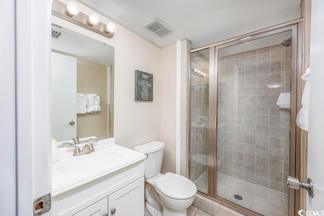 bathroom with vanity, toilet, tile patterned floors, and a shower with door