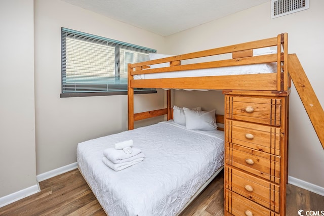 bedroom with dark wood-type flooring