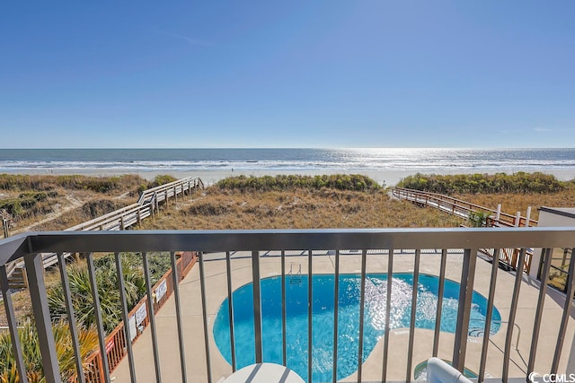 balcony with a water view and a beach view