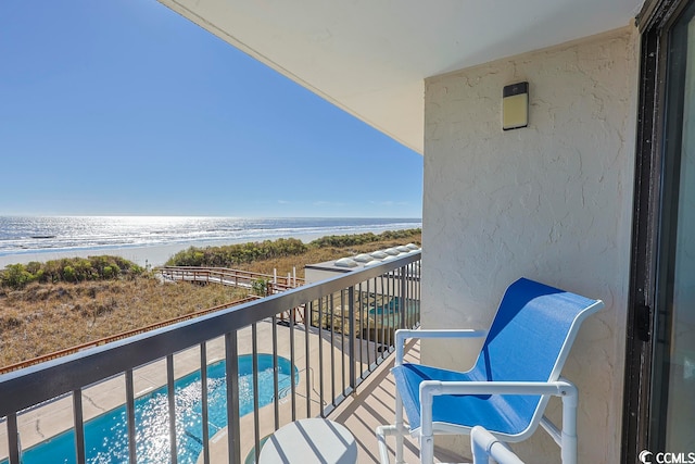 balcony featuring a water view and a beach view