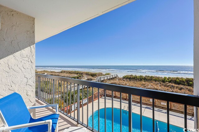 balcony featuring a water view and a beach view