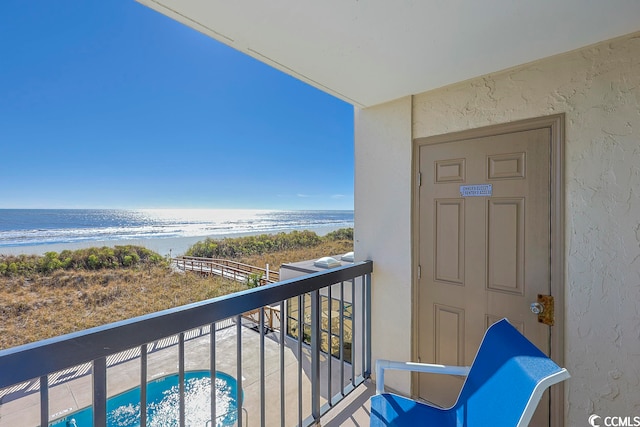 balcony with a water view and a beach view