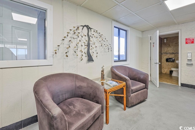 living area with a paneled ceiling