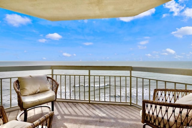 balcony featuring a view of the beach and a water view