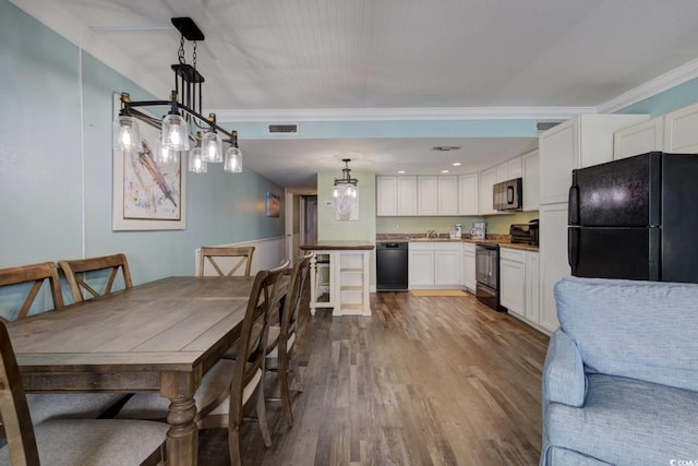 dining area featuring wood-type flooring and crown molding