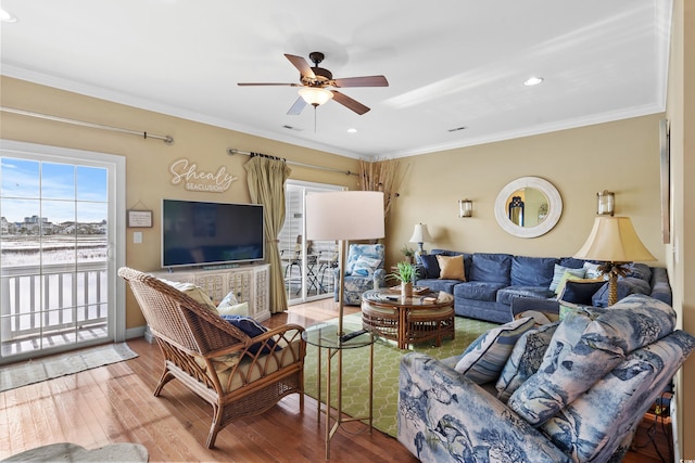 living room with wood-type flooring, ceiling fan, and crown molding