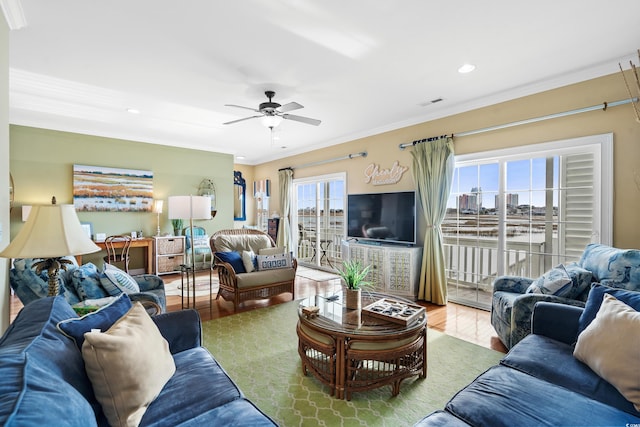 living room featuring a wealth of natural light, ceiling fan, light hardwood / wood-style floors, and ornamental molding