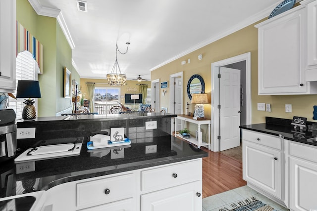 kitchen featuring white cabinets, light wood-type flooring, and ornamental molding