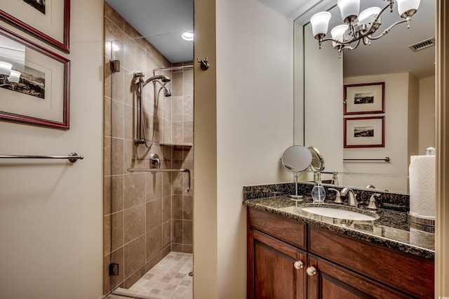 bathroom featuring vanity, an enclosed shower, and a chandelier