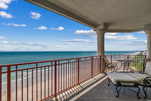 balcony with a water view and a beach view