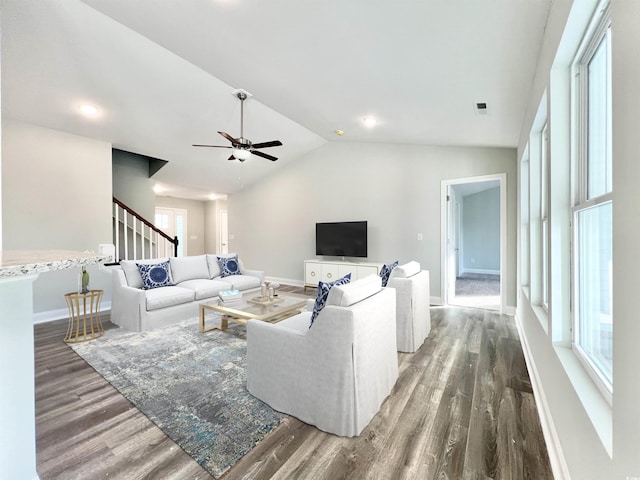 living room with dark wood-type flooring, ceiling fan, and vaulted ceiling