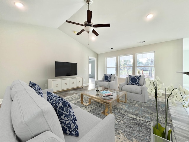 living room with ceiling fan, lofted ceiling, and hardwood / wood-style floors