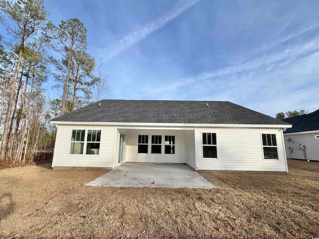 back of property with a patio area and a yard