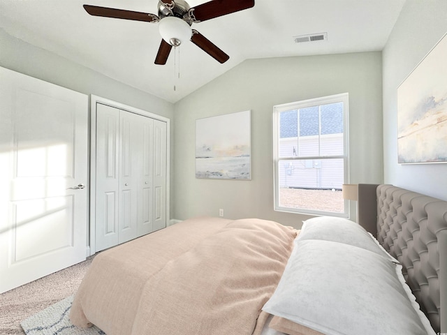 carpeted bedroom with a closet, ceiling fan, and lofted ceiling