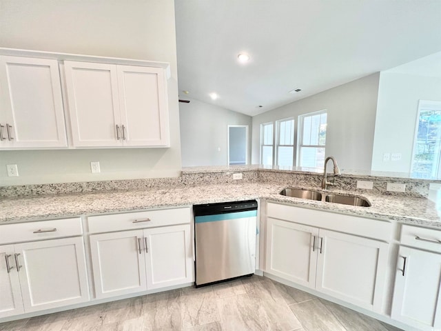 kitchen featuring light stone countertops, sink, vaulted ceiling, stainless steel dishwasher, and white cabinets